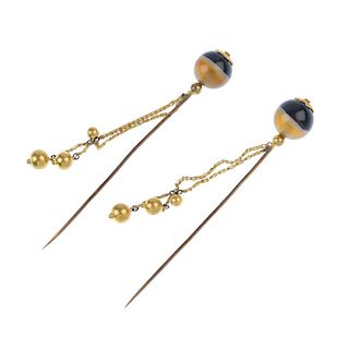 A pair of banded agate bead hatpins. Each designed as a banded agate sphere, with floral terminal, s