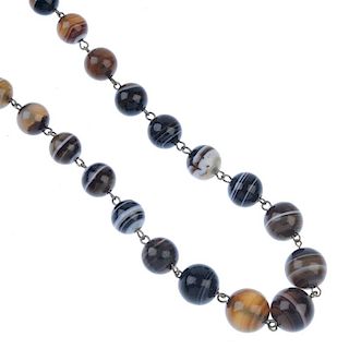 An agate necklace. Comprising twenty-five graduated spherical banded agate beads, to the push-piece