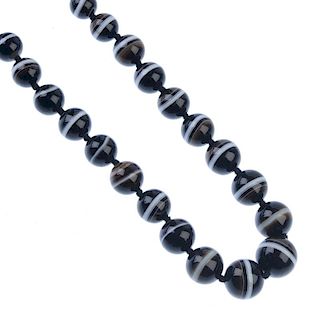 An agate bead necklace. Comprising a series of thirty-two spherical agate beads, to the partially co