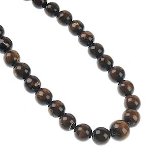 A golden coral bead necklace. Comprising twenty-nine spherical graduated beads of golden coral, meas