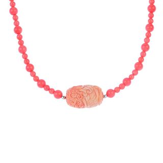 A treated bamboo coral and carved gem decorative spacer. The spherical treated bamboo coral beads, t