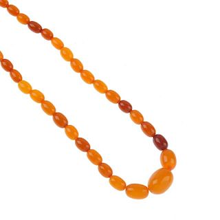 A natural amber bead necklace. The seventy-one oval-shape graduated beads, measuring 0.8 to 2.2cms.