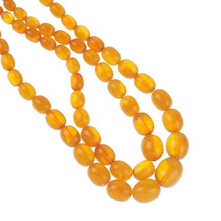 A natural amber necklace. Designed as two rows of  oval-shape graduated natural amber beads, measuri