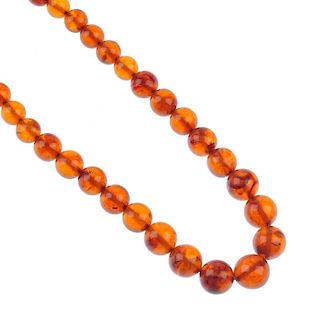 A reformed amber spherical bead necklace. Comprising thirty-three graduated spherical beads measurin