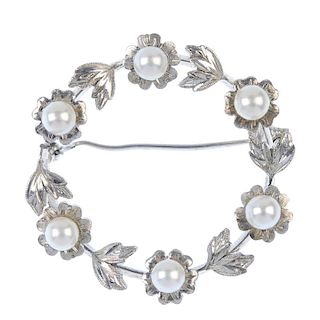 MIKIMOTO - a cultured pearl wreath brooch. Designed as a series of cultured pearl flowers, with foli