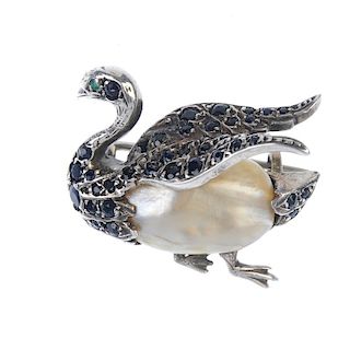 A sapphire, emerald and mother-of-pearl swan brooch. The oval-shape mother-of-pearl body, with circu