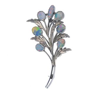 An Arts and Crafts silver opal and opal doublet floral brooch. Designed as a floral frond, the vari-