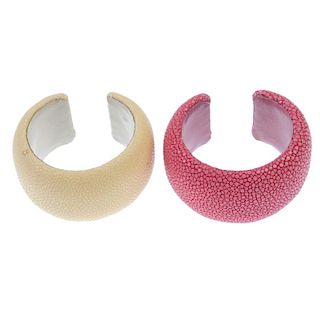 Two stingray cuffs. The two cuffs, one of pale yellow, the other of pinkish-red, to the leather lini