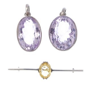 Two amethyst pendants and a citrine bar brooch. To include two oval-shape amethyst pendants and an o