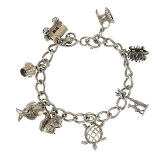 Two charm bracelets. Both designed as curb-link chains, suspending a total of fourteen charms, to in
