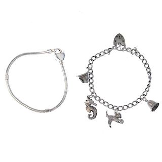 Two charm bracelets and a selection of charms. The snake chain bracelet with twenty-five loose charm