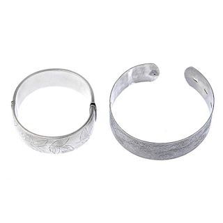 Two silver bangles. To include a 1940s silver floral embossed bangle and a 1960s silver foliate engr
