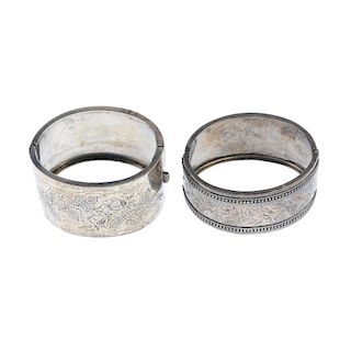 Two late Victorian silver hinged bangles. Each designed with foliate embossed detail. One with defic