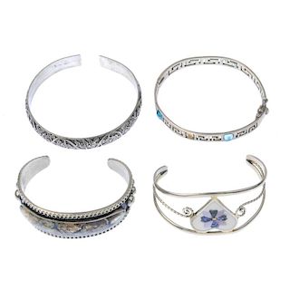 A selection of silver and white metal bangles. To include a broad hinged silver bangle, with acanthu