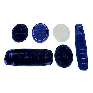 A bag containing display props. The blue velvet display props include a ring pads, earring stands, o