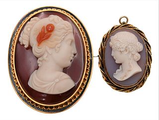Two Stone Cameos, mounted in 14 karat gold, the larger has a black enamel surround; largest 2 1/8 inches.