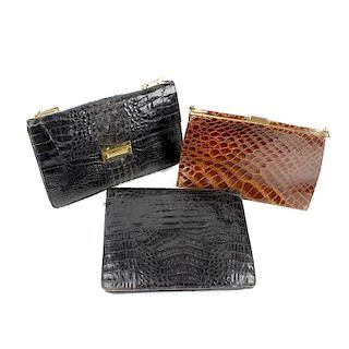 Three crocodile handbags. To include a black textured hornback example, featuring a front clip faste