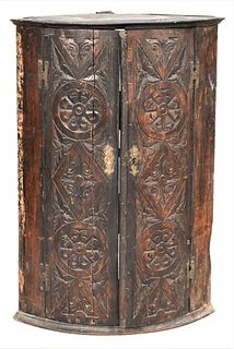 English Oak Corner Hanging Cabinet, having two carved doors, height 35 1/2 inches, depth 16 inches. Provenance: The Connoisseur Antiques, Illinois. Es