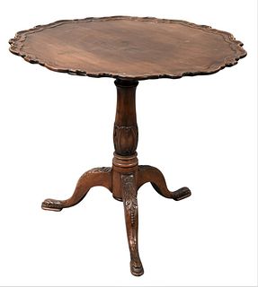 Mahogany Tip Table, having pie crust edge on carved pedestal and carved legs, ending in dolphin feet, height 29 inches, diameter 32 inches. Provenance