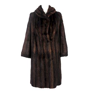 A full-length dyed musquash fur coat. Featuring a lapel collar, hook and eye fastenings, wide sleeve