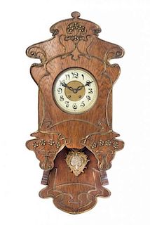 * An Art Nouveau Oak and Gilt Metal Mounted Wall Clock, Height 34 x width 16 3/8 inches.