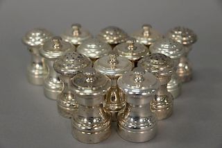Seven pairs of sterling silver salt shakers with pepper mills.