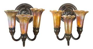 A Pair of Tiffany Studios Gold Favrile Glass and Bronze Three-Light Sconces, Height 7 1/4 x width 9 1/8 inches.