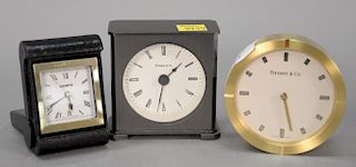 Three small clocks including Tiffany & Co. heavy brass round fan shelf clock Swiss Quartz, a Tiffany quartz 2100 shelf clock, and a ...