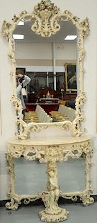 Italian carved marble top hall table and mirror having elaborately carved mirror over half round hall table having putti center leg....