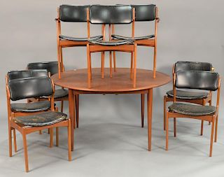 Erik Bach dining table with two 21 1/2" leaves and six chairs (cracks in leather). ht. 28 in.; dia. 53 in.; opens to 96 in.