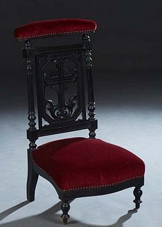 French Provincial Carved Ebonized Beech Prie Dieu, c. 1870, the curved cushioned armrest over a pierced cruciform splat flanked by turned supports, to