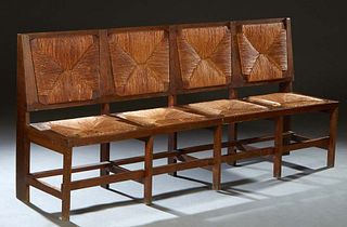 Unusual French Provincial Carved Oak Rushseat Bench, early 20th c., the rectangular back with four inset woven rush panels, over four rush slip seats,
