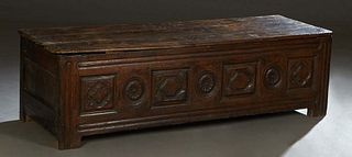 French Provincial Carved Oak Coffer, 19th c., the rounded corner lid over a front with seven relief carved panels, on block feet, H.- 21 in., W.- 69 1