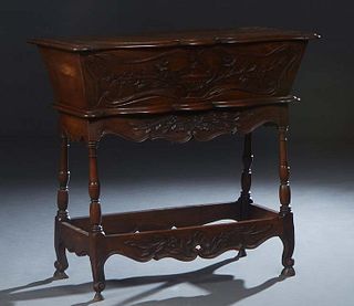French Provincial Carved Oak Petrin, 19th c., the stepped serpentine lid over a floral relief carved tapered panel, to a serpentine base, on a floral 