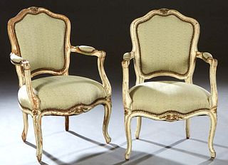Pair of French Louis XV Style Polychromed Beech Fauteuils, early 20th c., the floral carved serpentine crest rail over an upholstered shield shaped ba