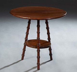 English Carved Oak Lamp Table, early 20th c., the circular top on turned tripodal legs, joined by a circular stretcher/shelf, H.- 22 in., Dia.- 22 1/4