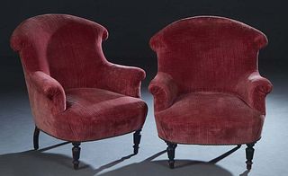 Pair of French Carved Walnut Bergeres, c. 1870, the curved wing back over rolled arms and a cushioned seat, on turned tapered legs, now in pale purple