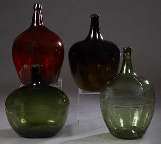 Group of Four Mold Blown Glass Wine Carboys, 19th c., two in green, one black, and one in brown, Largest- H.- 20 in., Dia.- 12 in. (4 Pcs.)