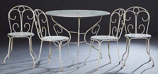 French Five Piece Wrought Iron Patio Set, 20th c., consisting of a circular table with a pierced top on scrolled legs, and four matching side chairs, 