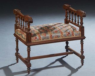 French Henri II Style Carved Walnut Piano Bench, late 19th c., the leaf carved arms over spindled sides, on turned tapered legs joined by square stret