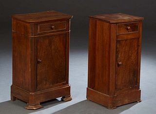 Group of Two French Louis Philippe Style Carved Walnut Nightstands, 19th c., with canted corner tops over frieze drawers and long cupboard doors, on p