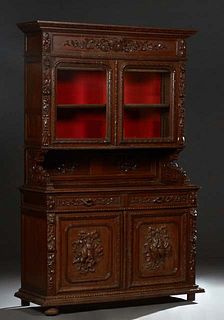 French Henri II Style carved Oak Buffet a Deux Corps, the ogee stepped crown over double glazed doors, flanked by fruit and nut carved pilasters, on c