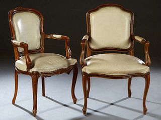 Near Pair of Louis XV Style Carved Beech Fauteuils, early 20th c., the curved floral carved upholstered back to upholstered arms and an upholstered bo