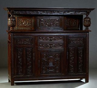 French Renaissance Style Carved Oak Buffet a Deux Corps, 19th c., the stepped ogee crown over a center cupboard door with iron strap hinges and escutc