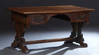Spanish Renaissance Style Carved Oak Writing Table, early 20th c., the rounded corner rectangular top over a carved skirt and two deep drawers, on a p
