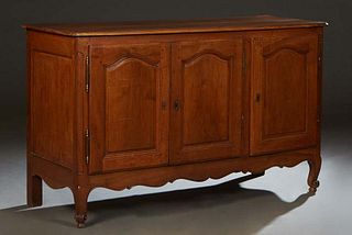 French Louis XV Style Carved Cherry Sideboard, 19th c., the stepped rounded edge and corner two board top over three fielded panel cupboard doors with