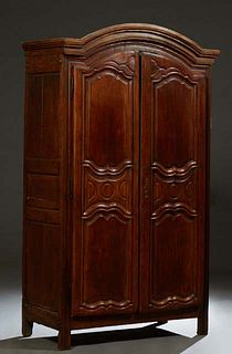 French Provincial Louis XVI Style Carved Walnut Armoire, early 19th c., the arched stepped crown over double three panel doors with iron escutcheons a