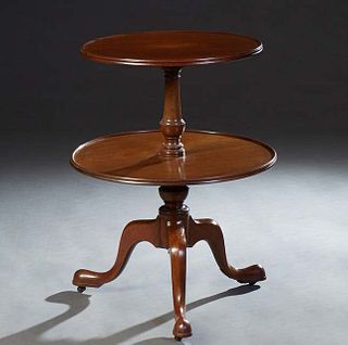 English carved Mahogany Two Tier Dumbwaiter, c. 1910, the stepped edge circular top on an urn form support, to a like larger shelf on a turned support