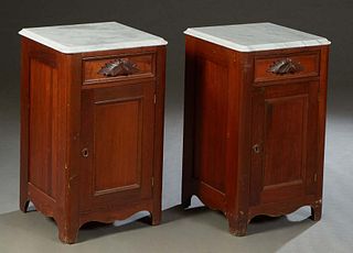Pair of American Carved Walnut Marble Top Nightstands, c. 1880, the later ogee edge figured white marble over a frieze drawer with a leaf carved pull,