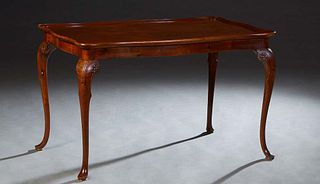 English Carved Mahogany Center Table, early 20th c., the stepped rounded edge tortoise top over a carved skirt, on floral carved cabriole legs with pa